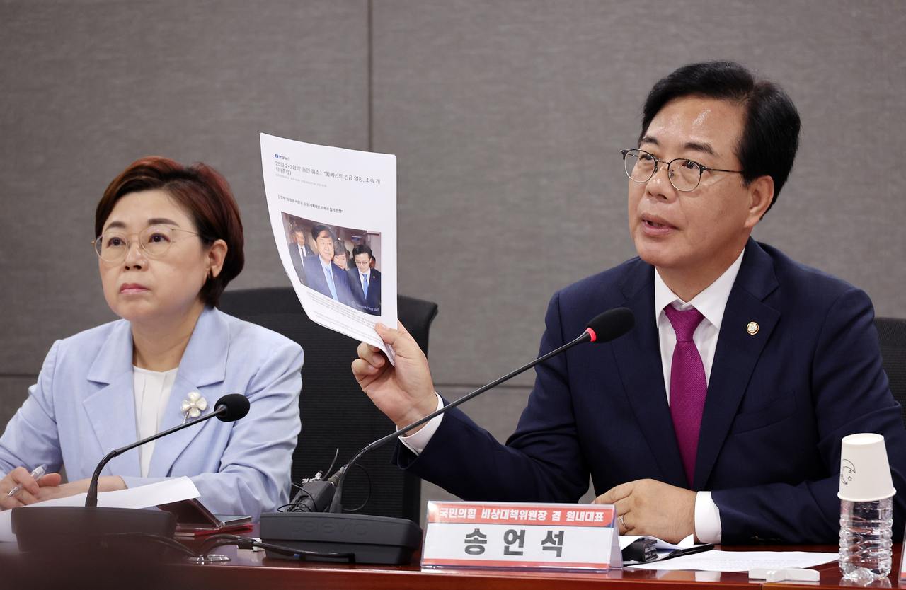 Rep. Song Eon-seog (right), interim leader of the People Power Party, speaks during an emergency meeting with farmers' groups at the National Assembly in Yeouido, Seoul, Thursday, holding up printed news reports about the cancellation of the 2+2 meeting between South Korea and the United States. (Yonhap)