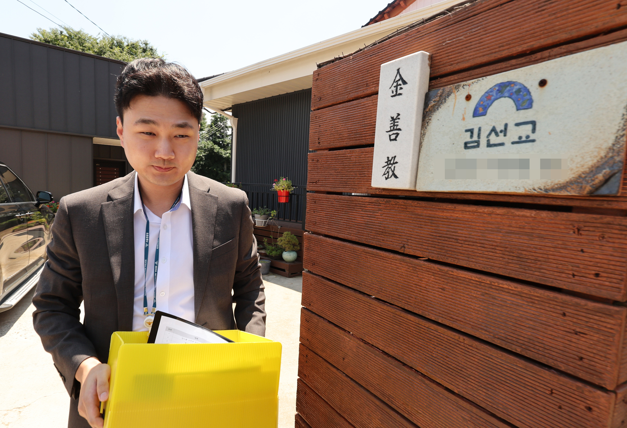 A member of the special investigative team carries a box containing seized documents and other items during a raid on the residence of Rep. Kim Sun-gyo in Yangpyeong, Gyeonggi Province, on Friday. (Yonhap)