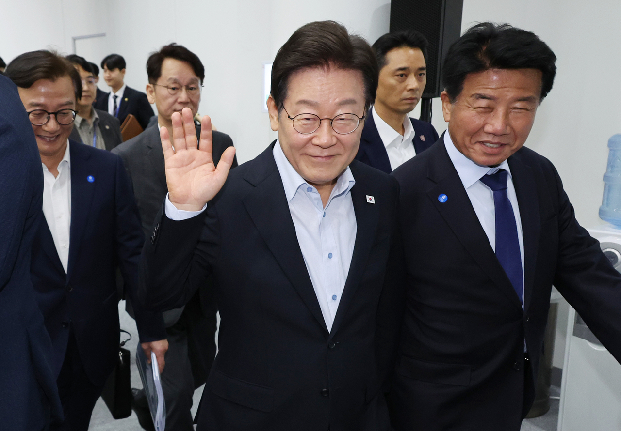 President Lee Jae Myung (center) waves his hand after his meeting with Busan citizens on Friday (Yonhap)
