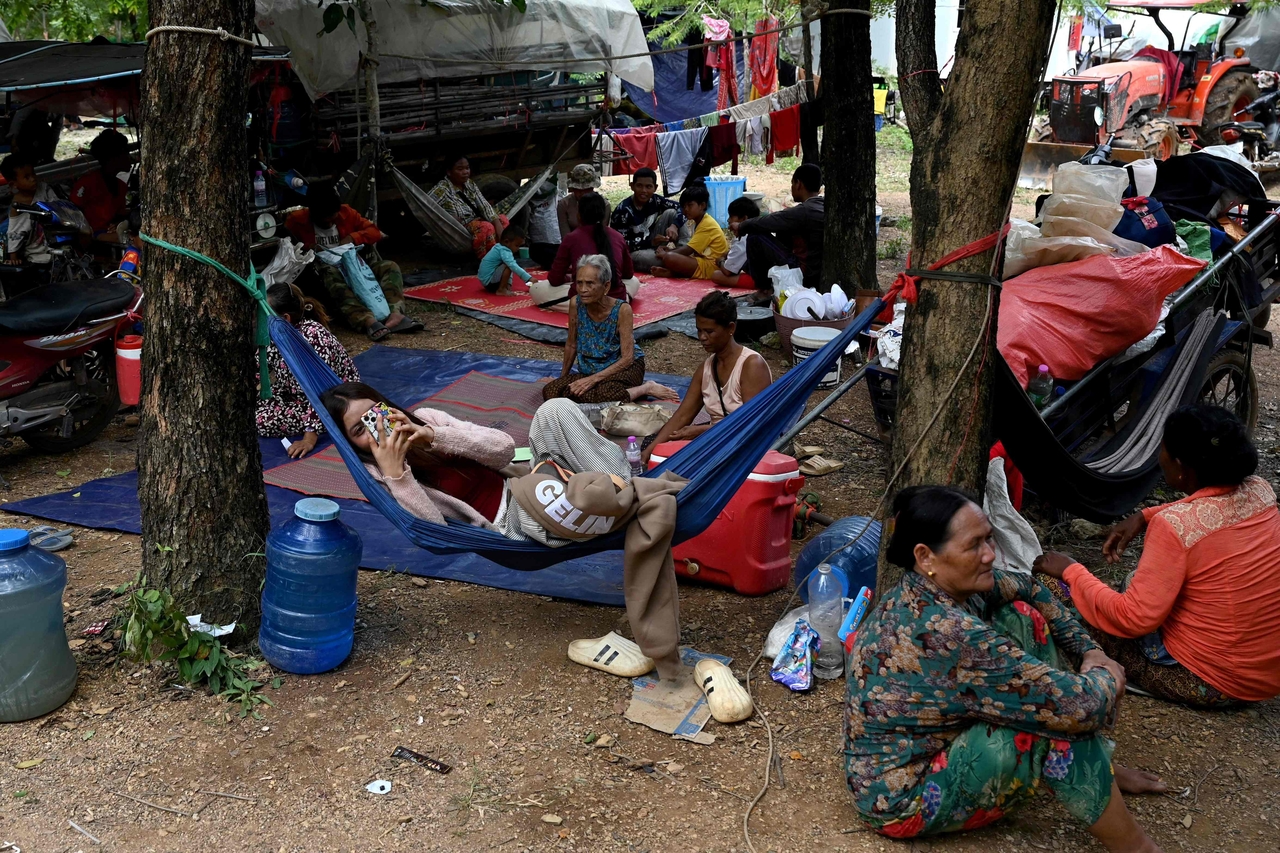 People who fled their homes near the Cambodia-Thailand border rest on the grounds of a pagoda in Oddar Meanchey province on Friday. Thailand's acting Prime Minister Phumtham Wechayachai warned the same day that cross-border clashes with Cambodia that have uprooted more than 130,000 people "could develop into war," as the countries traded deadly strikes for a second day. (AFP-Yonhap)