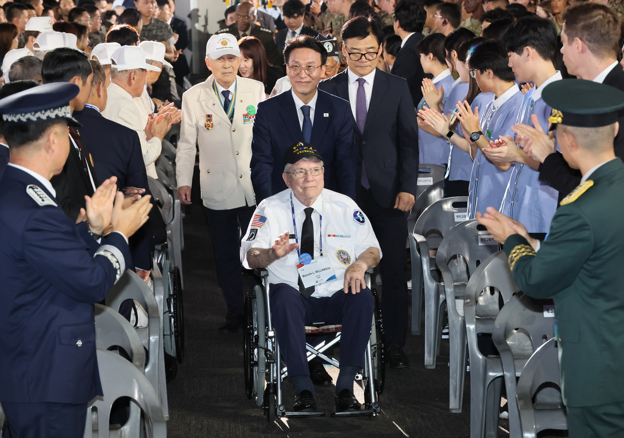 Prime Minister Kim Min-seok pushes the wheelchair of a Korean War veteran during a ceremony held at Kintex in Goyang, Gyeonggi Province, Sunday, to celebrate the UN Forces Participation Day. (Yonhap)