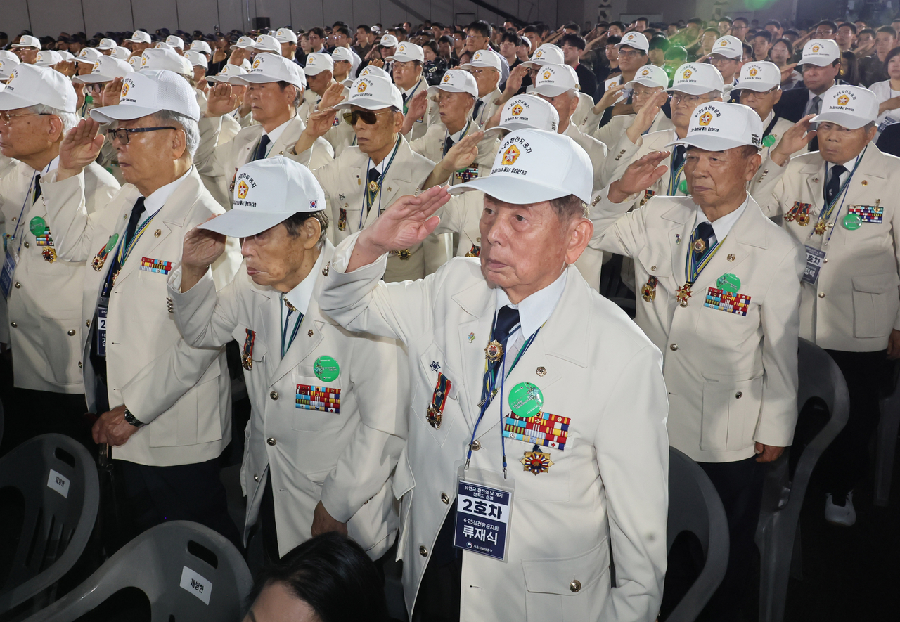 Korean War veterans salute the national flag during the ceremony. (Yonhap)