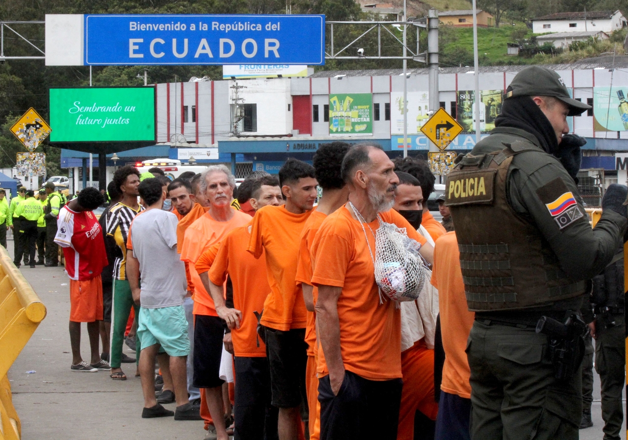 Inmates queue up before being deported to Colombia at the Rumichaca international bridge between Tulcan, Ecuador and Ipiales, Colombia, Saturday. (AFP-Yonhap)