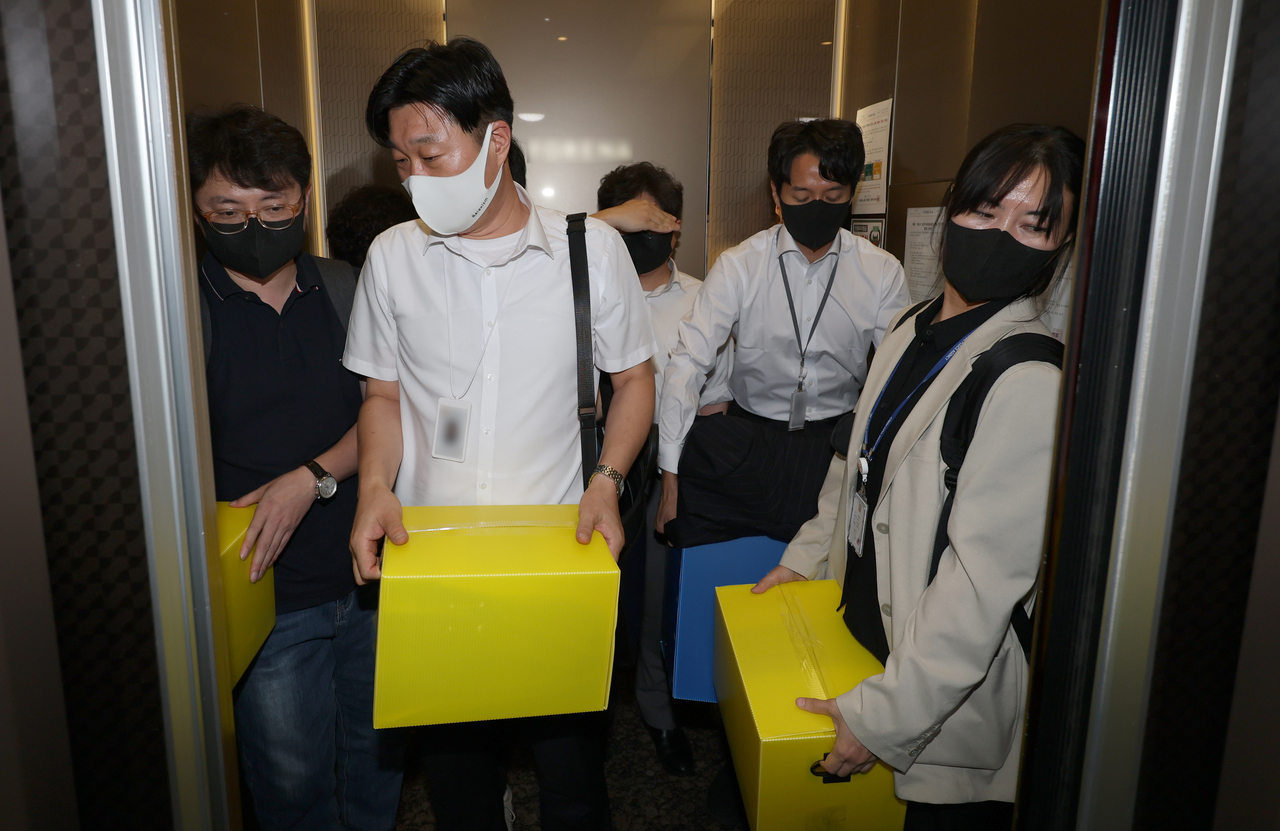 Investigators from special prosecutor Min Joong-ki's team carry confiscated items after completing a search at the residence of Lee Jun-seok, leader of the minority opposition New Reform Party, in Seoul on Monday. (Yonhap)