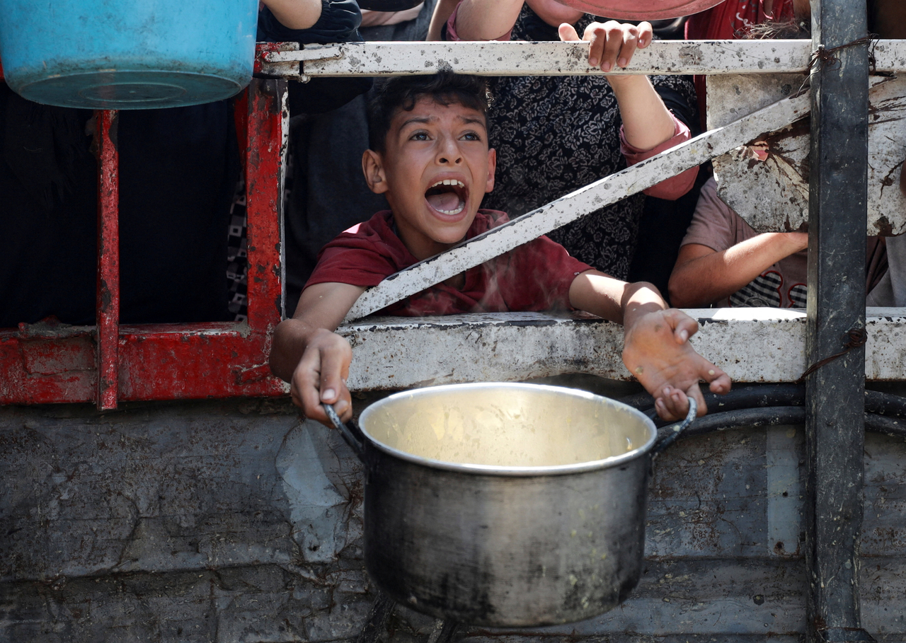A Palestinian reacts as he waits to receive food from a charity kitchen, amid a hunger crisis, in Gaza City, Monday.   Reuters-Yonhap