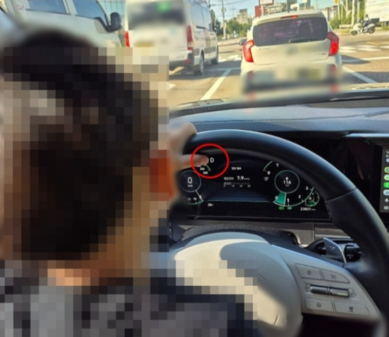 This photo, showing a young boy sitting in the driver’s seat of a car on a road, was posted by his purported mother on an online community for mothers, along with the caption, “(My boy) really likes to take the wheel.” The post has since been deleted. (Naver online community)