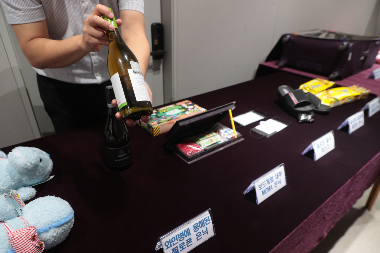 A customs official displays a wine bottle used to smuggle narcotics during a press conference in Seoul on Tuesday. (Yonhap)
