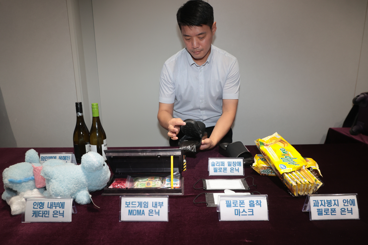 A customs official displays a slipper, showing how the back of the sole was used to conceal narcotics. (Yonhap)