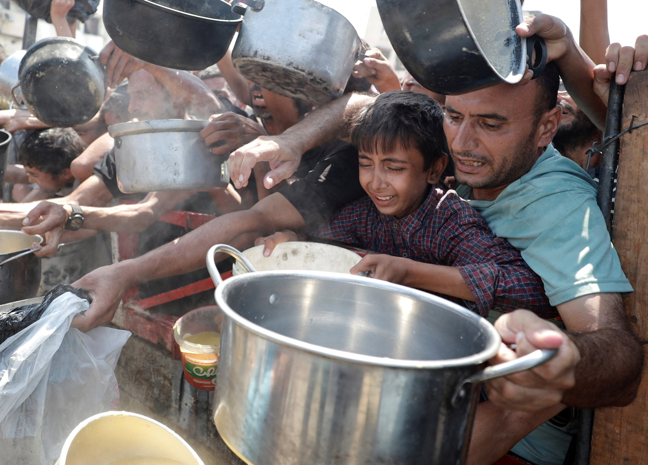 Palestinians gather to receive food from a charity kitchen, amid a hunger crisis, in Gaza City, Monday.  Reuters-Yonhap