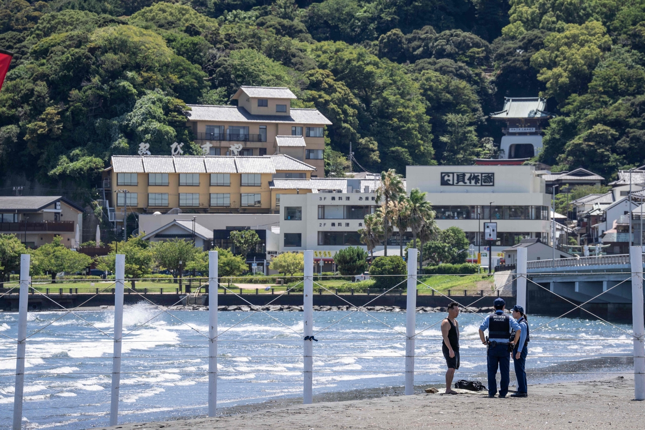 Police officers ask a man to evacuate an empty beach due to a tsunami warning in Fujisawa city, Kanagawa prefecture on Wednesday. Tsunamis hit parts of Russia's Far East and Japan on July 30 after a huge magnitude 8.8 earthquake, with warnings in place around the Pacific of waves of over three metres in places. (AFP via Yonhap)