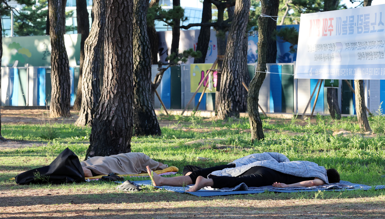 People rest in the shaded forest near the beach in Gangneung, Gangwon Province, Monday morning. (Yonhap)