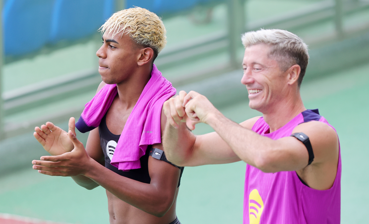 Lamine Yamal (left) and Robert Lewandowski enter the pitch at Goyang Stadium in Goyang, Gyeonggi Province, for a training session on Wednesday, the eve of their preseason match against FC Seoul. (Yonhap)
