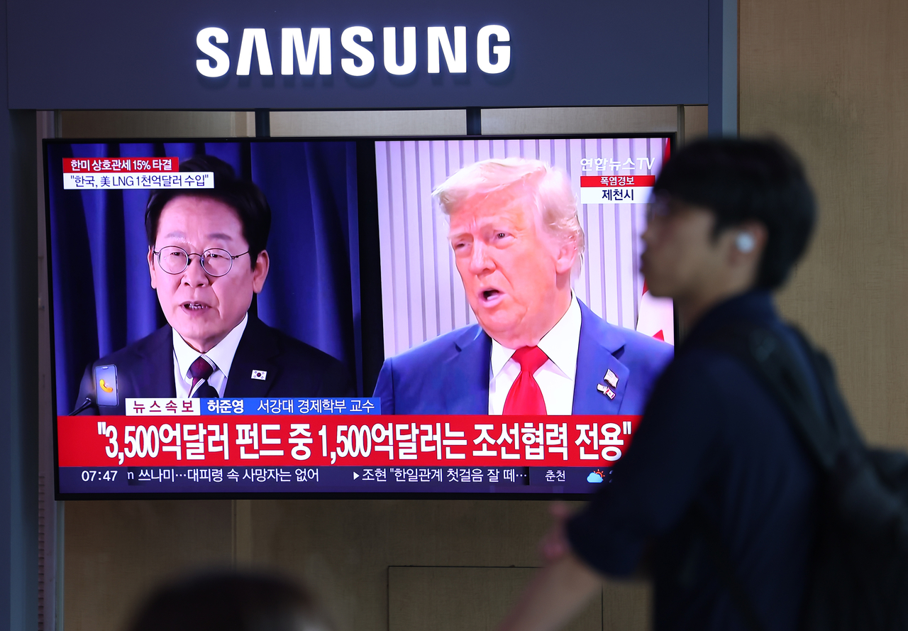 A pedestrian walks past a TV screen in Seoul Station on Thursday. (Yonhap)