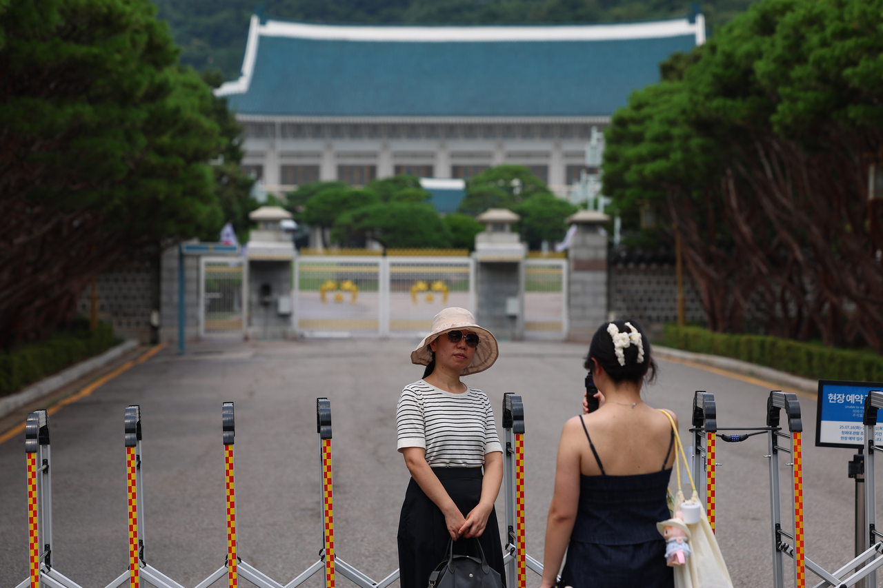 A visitor poses in front of Cheong Wa Dae in Seoul on Thursday, one day before it closes to the public. (Yonhap)