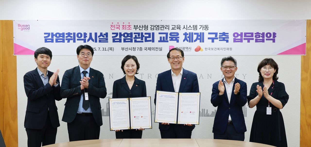 한국보건복지인재원은 7월 31일 부산광역시청 7층 의전실에서 ‘감염취약시설 감염관리 교육 체계 구축 업무협약’을 체결했다. 배금주 인재원 원장(사진 왼쪽 세 번째부터)과 이준승 부산시 행정부시장을 비롯한 참석자들이 기념촬영을 하고 있다.[부산광역시 제공]