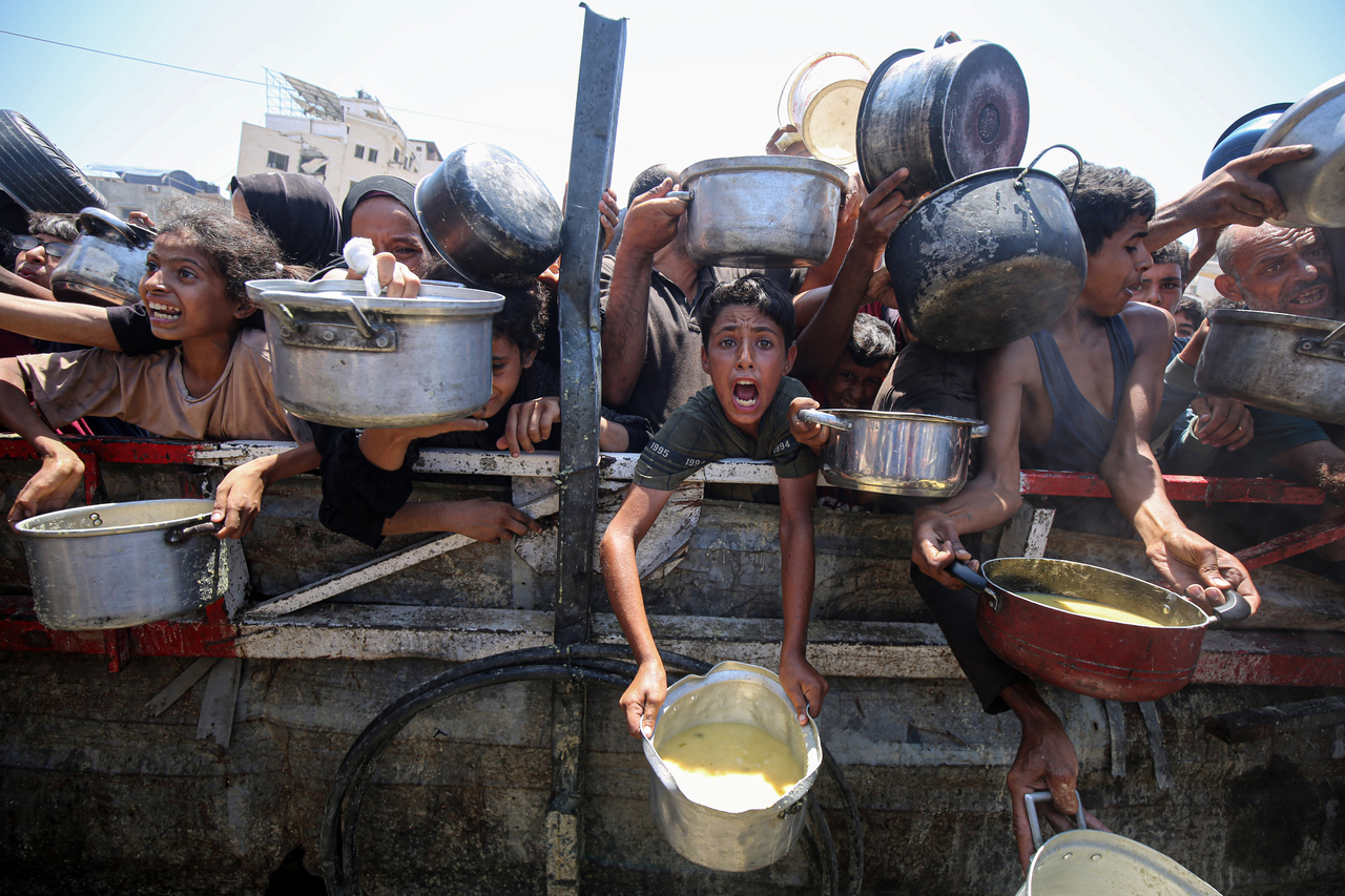 Palestinians wait to receive free food from a food distribution center in Gaza City, Saturday.   (Xinhua-Yonhap)