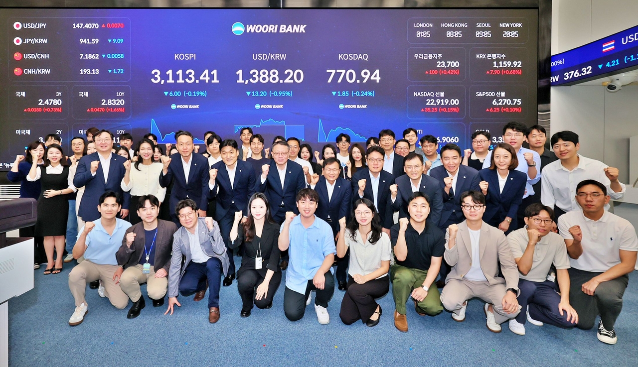 정진완(앞에서 두번째 줄 왼쪽 다섯 번째) 우리은행장이 4일 서울 중구 회현동 본점 자금시장그룹 딜링룸 전광판 점등식에서 임직원과 기념촬영을 하고 있다. [우리은행 제공]