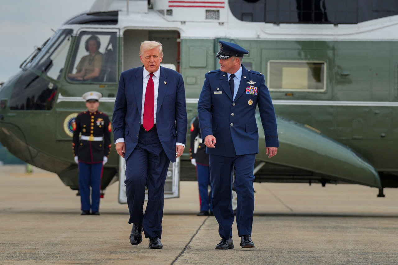 US President Donald Trump (left) walks with Col. Christopher Robinson 89th Airlift Commander after stepping off Marine One at Joint Base Andrews, Maryland, Friday. (Reuters-Yonhap)