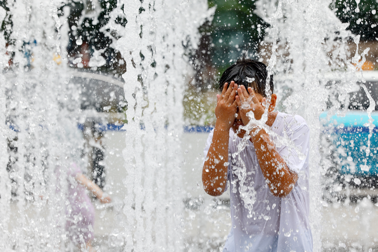 A child plays in the Myeongnang Fountain installed at the Gwanghwamun Square in Jongno-gu, central Seoul on Aug. 1. (Yonhap)