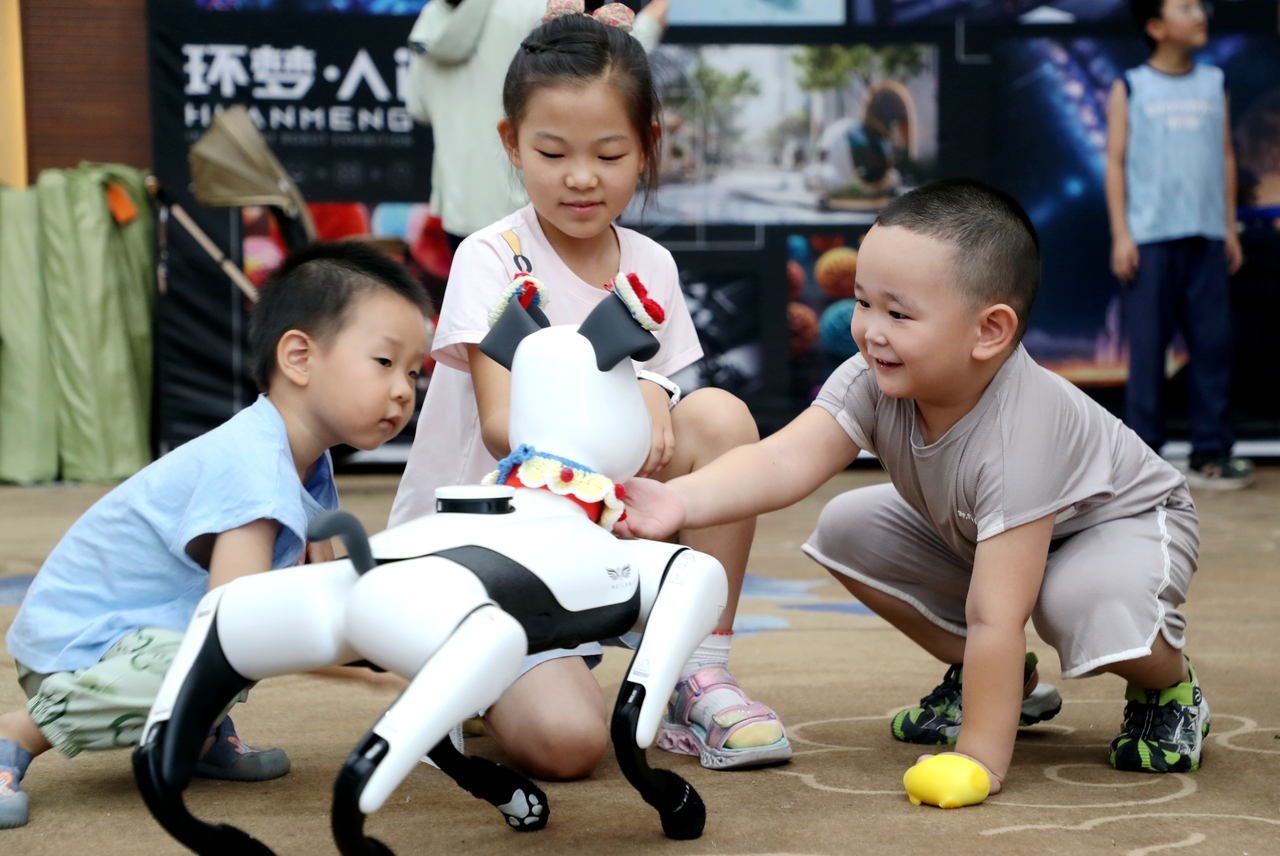Children interact with a robot dog at an AI robot exhibition in Dongying, east China's Shandong Province, Sunday. (Xinhua-Yonhap)