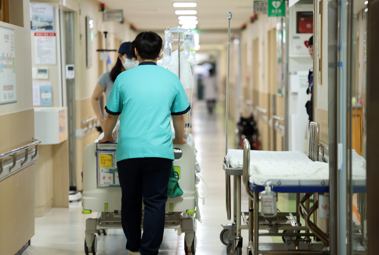 Officials move a hospital bed in a hospital in Gwangju (Yonhap)