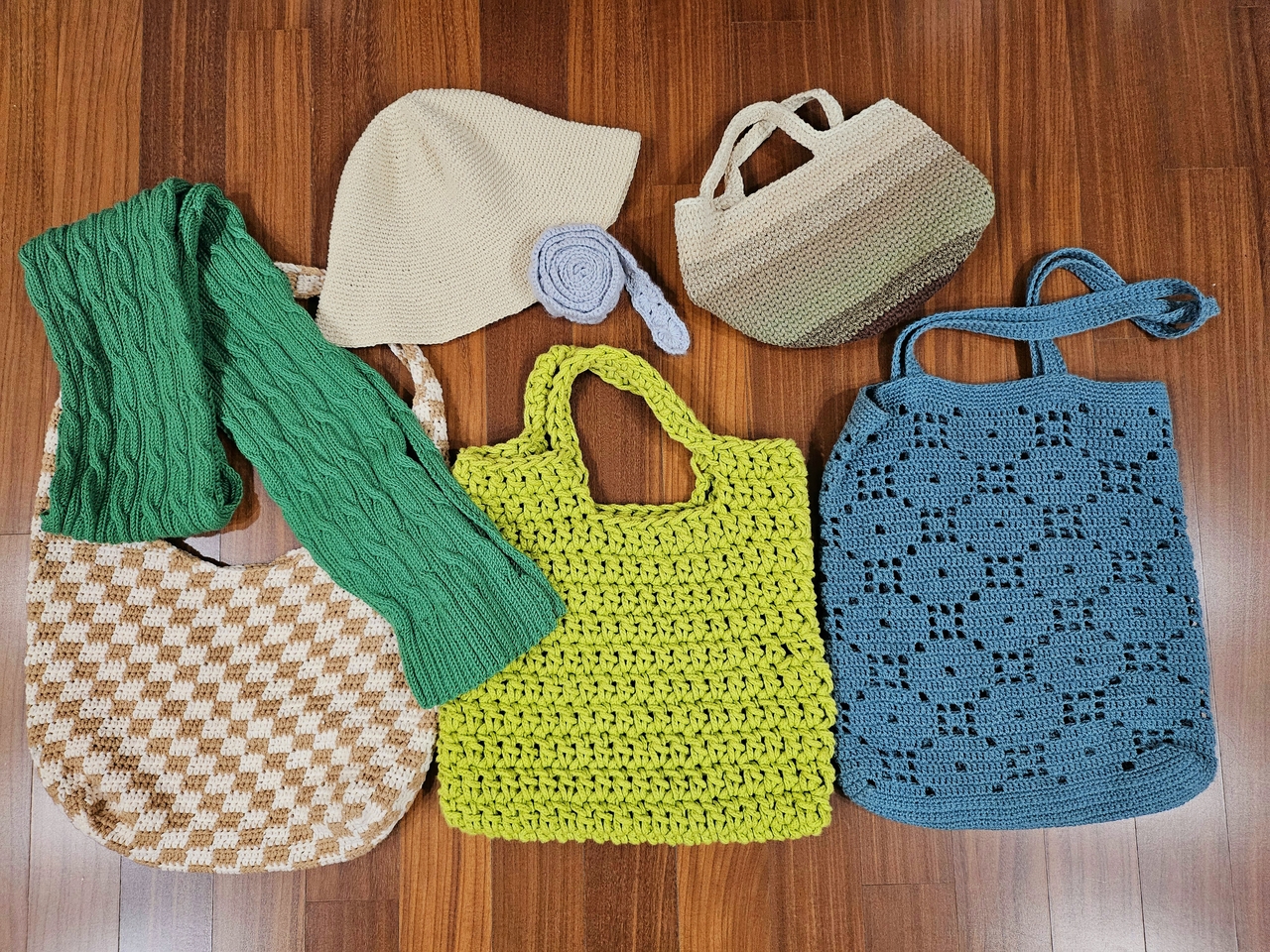 Bags, scarves and a hat knitted by Kim are laid out on the floor. (Kim)