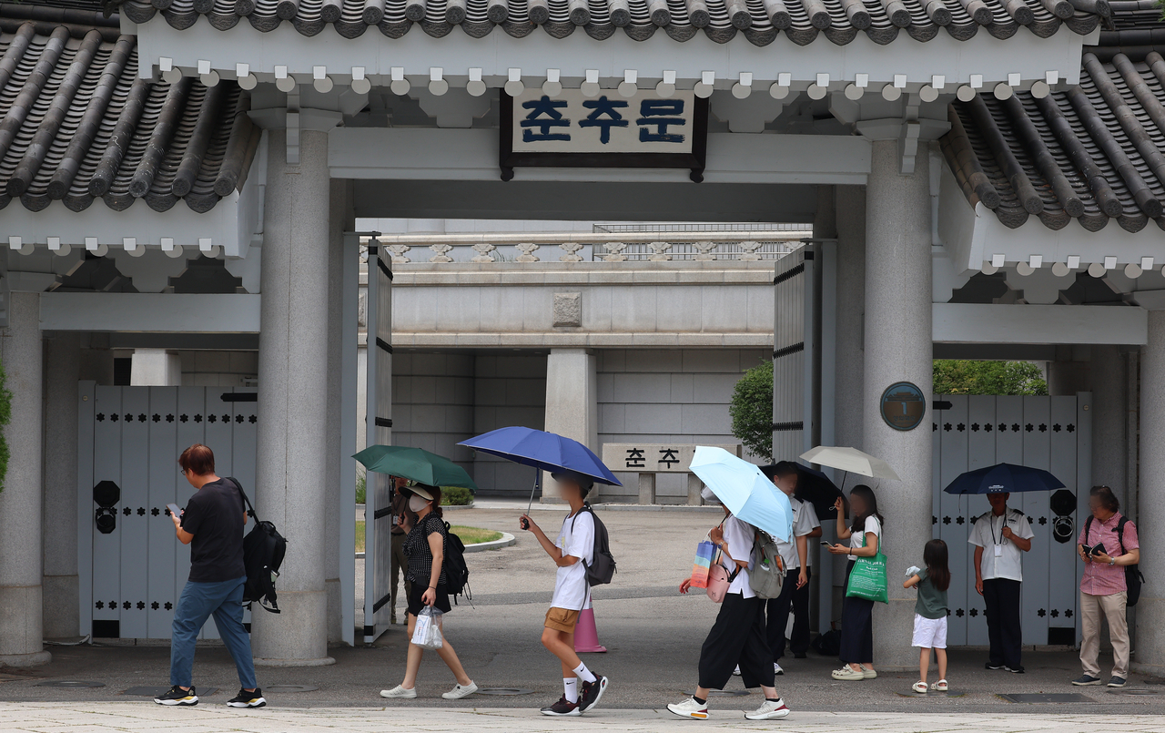 Visitors walk past a gate at the Cheong Wa Dae compound on Thursday. (Yonhap)