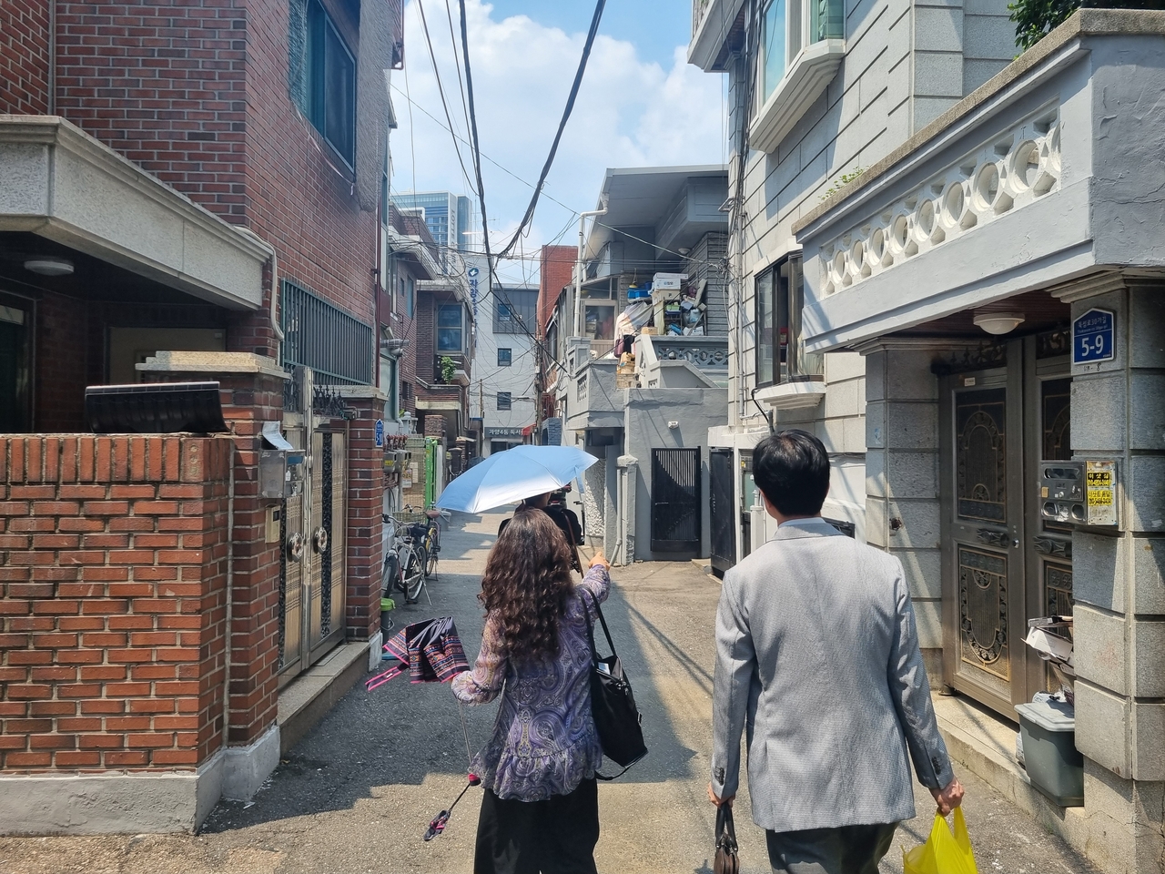 강인옥 통계청 서울사무소 고용통계1팀장과 박진자 통계조사관이 7월 28일 37도를 웃도는 서울 광진구 자양4동 주택가 골목을 걷고 있다.  김용훈 기자