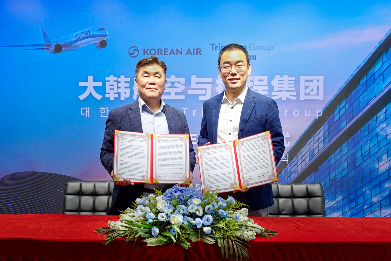 Park Yo-han (left), Korean Air's regional director for China, and Zhang Yong, CEO of the flight business division at Trip.com, pose for a photo during a partnership signing ceremony in Shanghai on Wednesday. (Korean Air)
