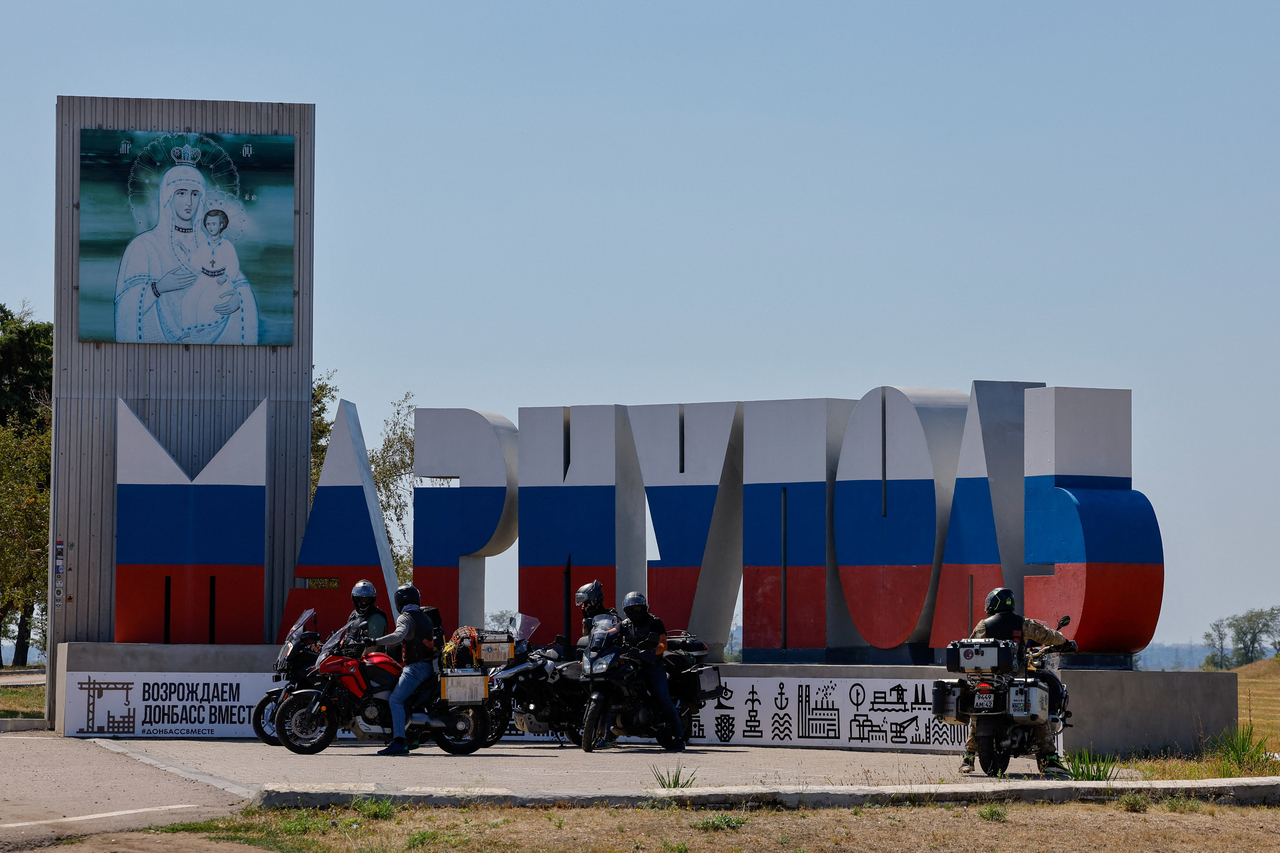 In Mariupol, a city in Ukraine under Russian control amidst the Russia-Ukraine military conflict, bikers are seen in front of a monument where the city's name is painted in the colors of the Russian state flag on Aug. 6.  (Reuters)