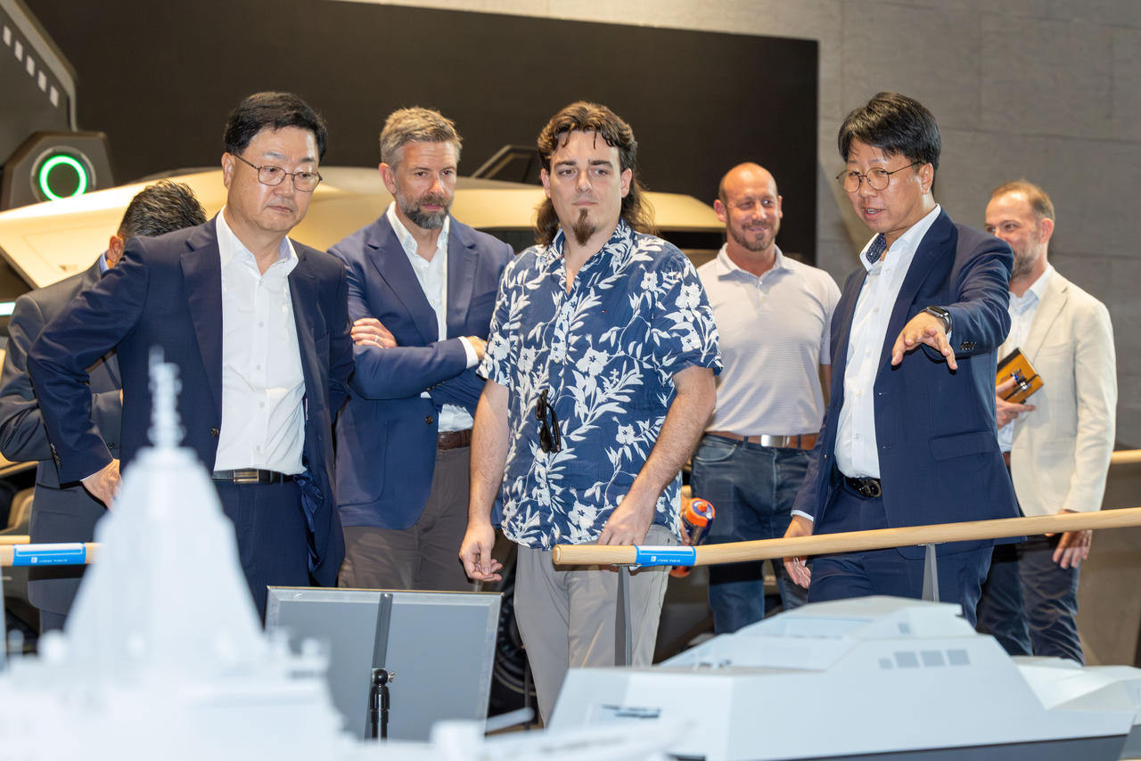 Palmer Luckey (center), co-founder of Anduril Industries, is briefed on HD Hyundai's uncrewed surface vessel at the shipbuilder's R&D center in Pangyo, Gyeonggi Province, Wednesday. (HD Hyundai)