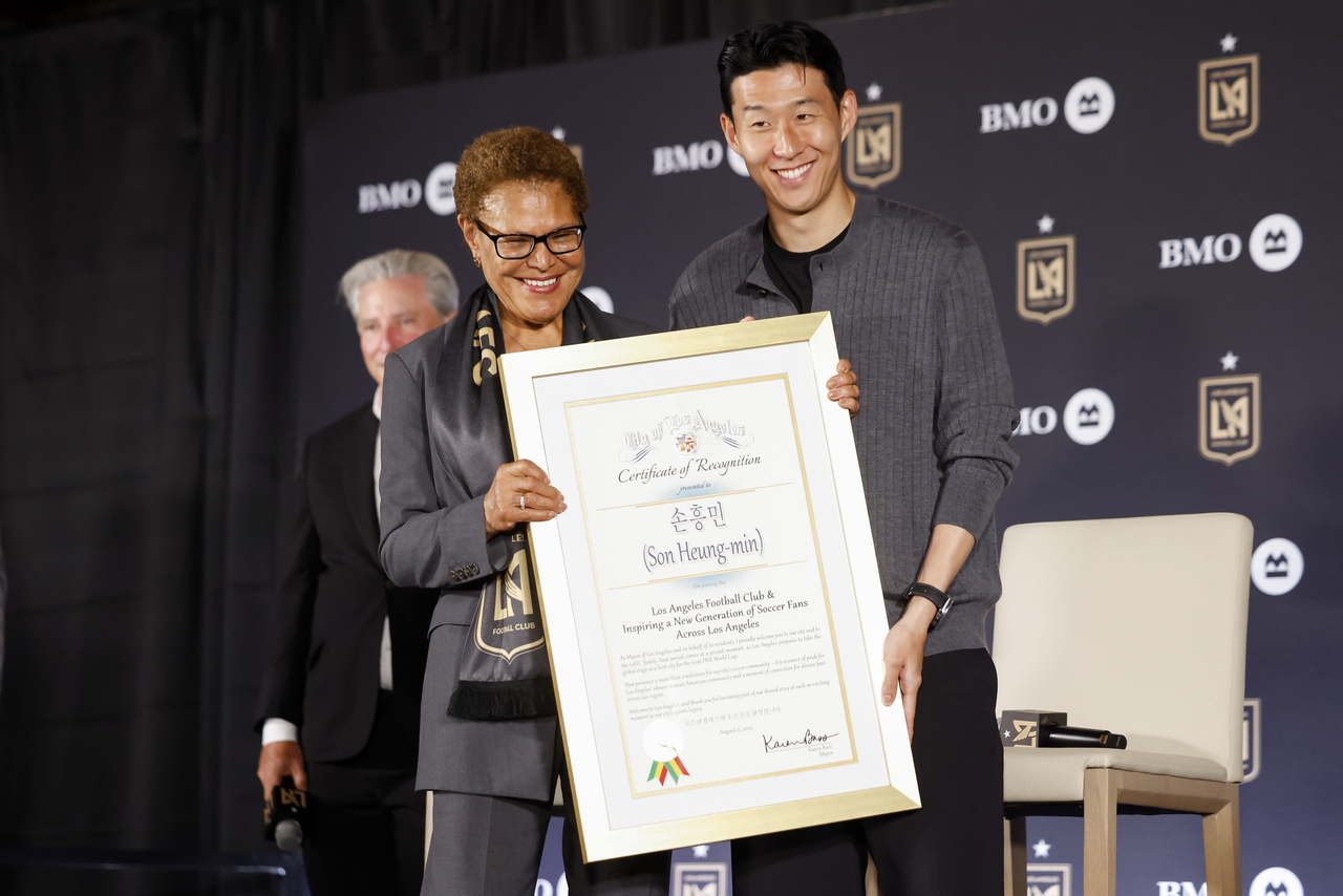 프리미어토토이 7일(한국시간) LAFC 입단 기자회견에서 캐런 배스(왼쪽) LA 시장으로부터 기념패를 받고 있다. [EPA]