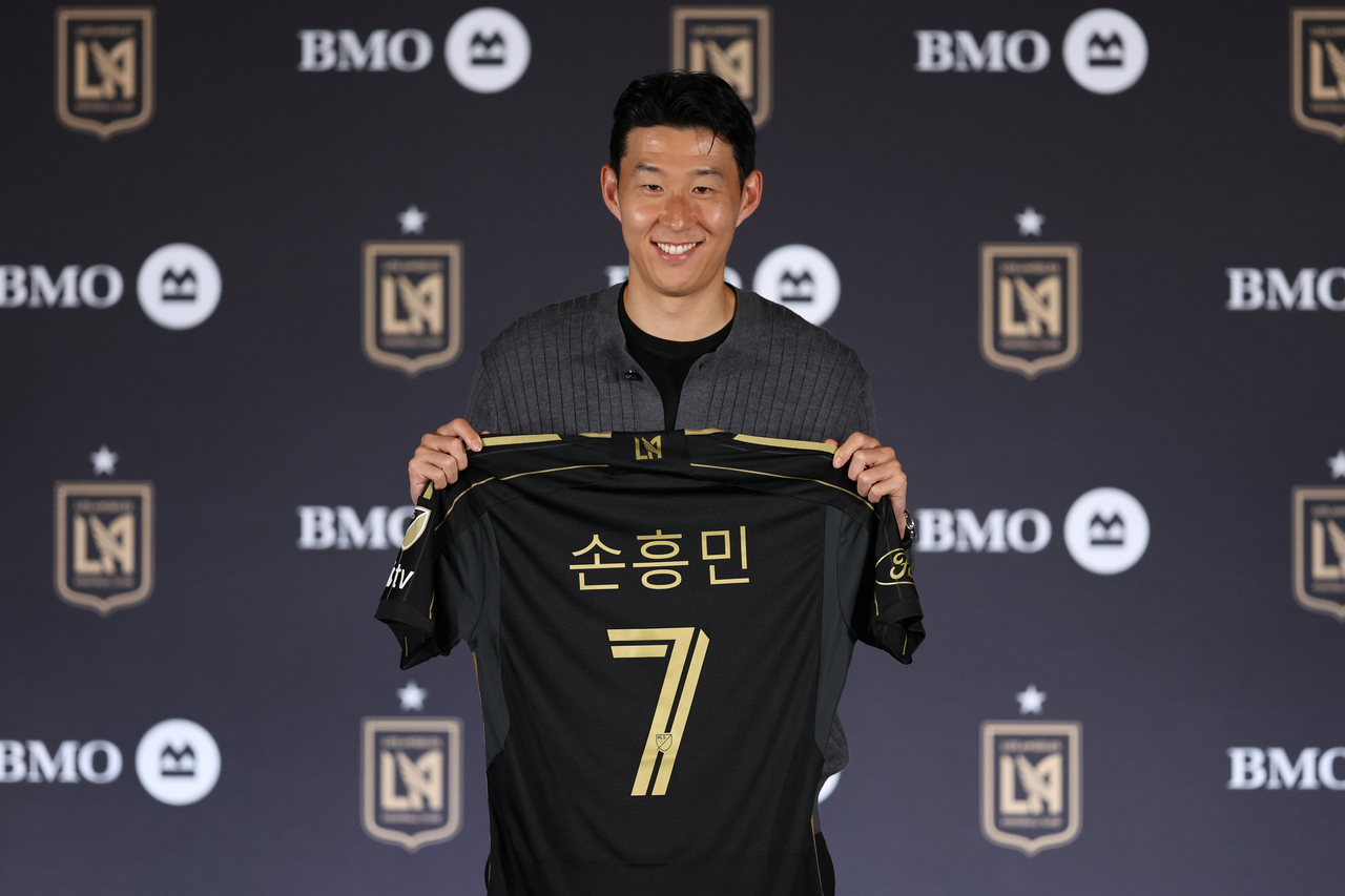 손흥민이 6일(현지시간) 미국 로스앤젤레스(LA) BMO 스타디움에서 열린 로스앤젤레스FC(LAFC) 입단 기자회견에서 유니폼을 들고 기념촬영을 하고 있다. [연합]