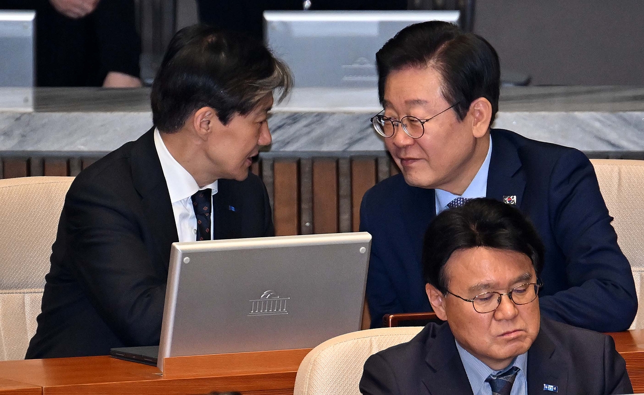 Former Rebuilding Korea Party leader Cho Kuk (left) speaks to then-Democratic Party of Korea leader Lee Jae Myung (right) druing a plenary session held in the National Assembly in Seoul on Nov. 28, 2024. (Lee Sang-sub/The Korea Herald)