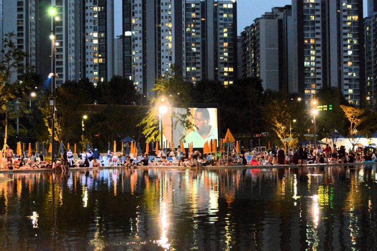 People watch a movie while enjoying a swim by the Han River. (Hangang River Festival)