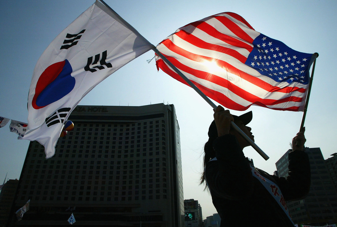 A Conservative South Korean women holds a South Korean and US flag during the celebration of The March First Independence Movement Anniversary on March 1, 2005 in Seoul, South Korea. (Getty Images)