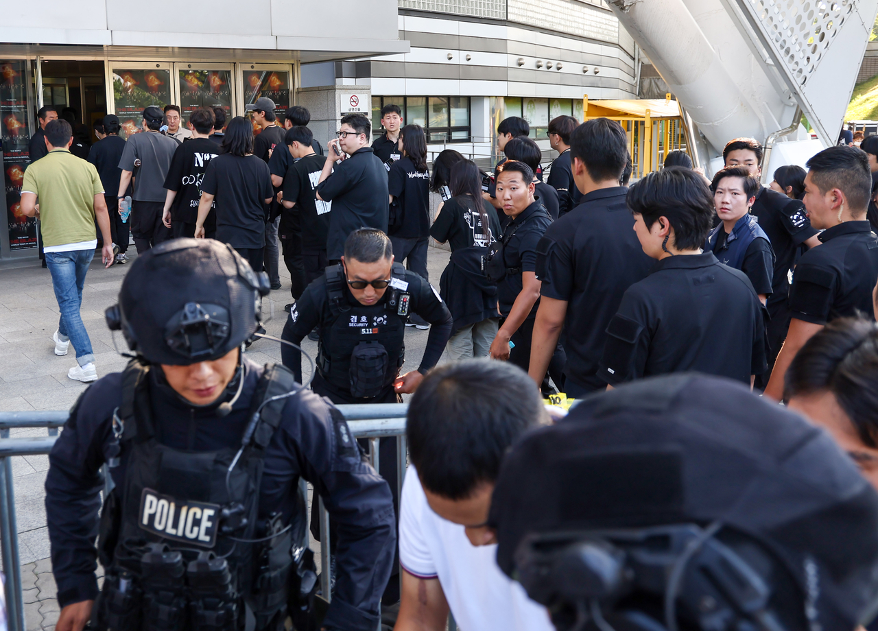 Staff involved in The Boyz concert reenter the KSPO Dome in the Olympic Park in Songpa-gu, Seoul, Sunday, after a police search confirmed that there were no explosives inside the building. (Yonhap)
