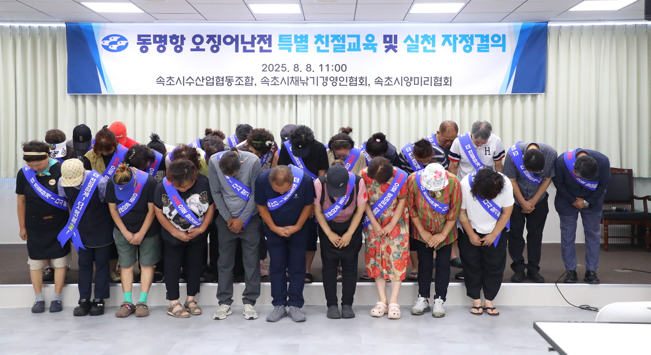 Vendors at the Dongmyeong Port Squid Market in Sokcho, Gangwon Province, hold a meeting on Friday at the National Federation of Fisheries Cooperatives in Sokcho to apologize for a recent customer service dispute and to pledge measures to prevent recurrence. (Yonhap)