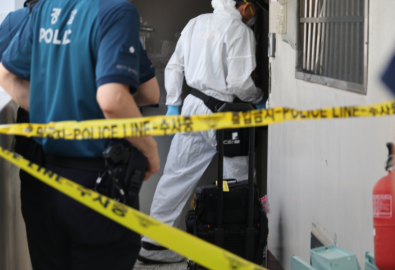 Police inspect the scene of a fire that killed three members of a family in Daegu on Sunday. (Yonhap)