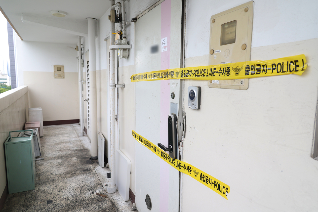 A police line is set up at the door of the apartment in Dong-gu, Daegu, where a fire killed three members of a family on Sunday. (Yonhap)