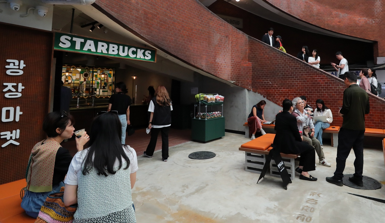 Customers are seen at the Gwangjang Market branch of Starbucks in downtown Seoul on May 29. The location blends the market’s history into a retro interior as part of a series of special-concept stores. Starbucks Korea ended 2024 with 2,009 outlets, moving past Japan for the first time and placing behind only the US and China in store numbers. (Starbucks Korea)