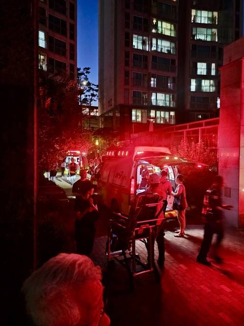 Paramedics transport two men injured in an attack by an unknown man in his 20s  at an apartment in Seongbuk-gu, Seoul. (Yonhap)