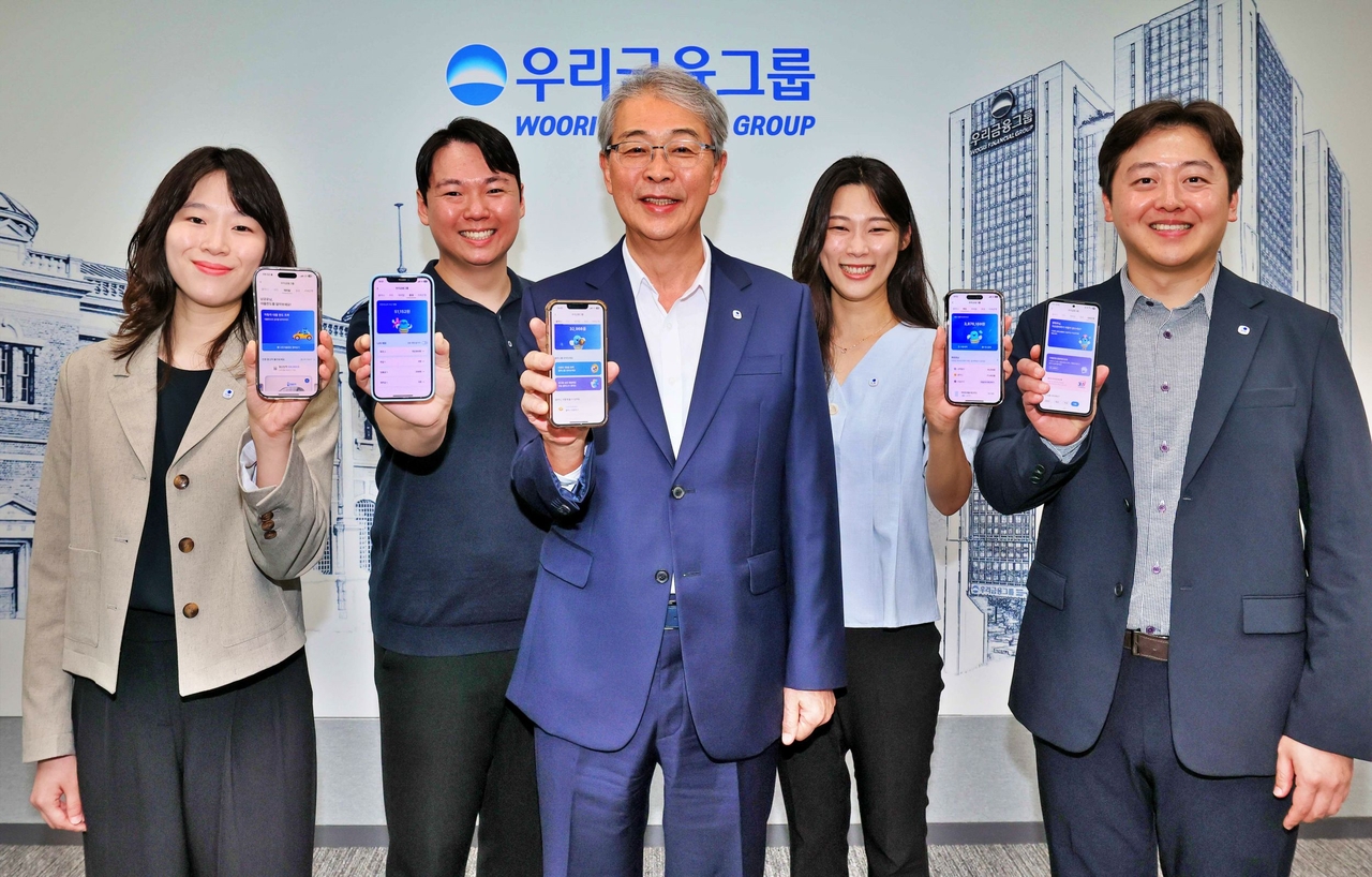 임종룡(가운데) 우리금융그룹 회장이 지난 6일 유니버설뱅킹 신규 가입자 100만명 돌파를 기념해 직원들과 기념촬영을 하고 있다.  [우리금융 제공]