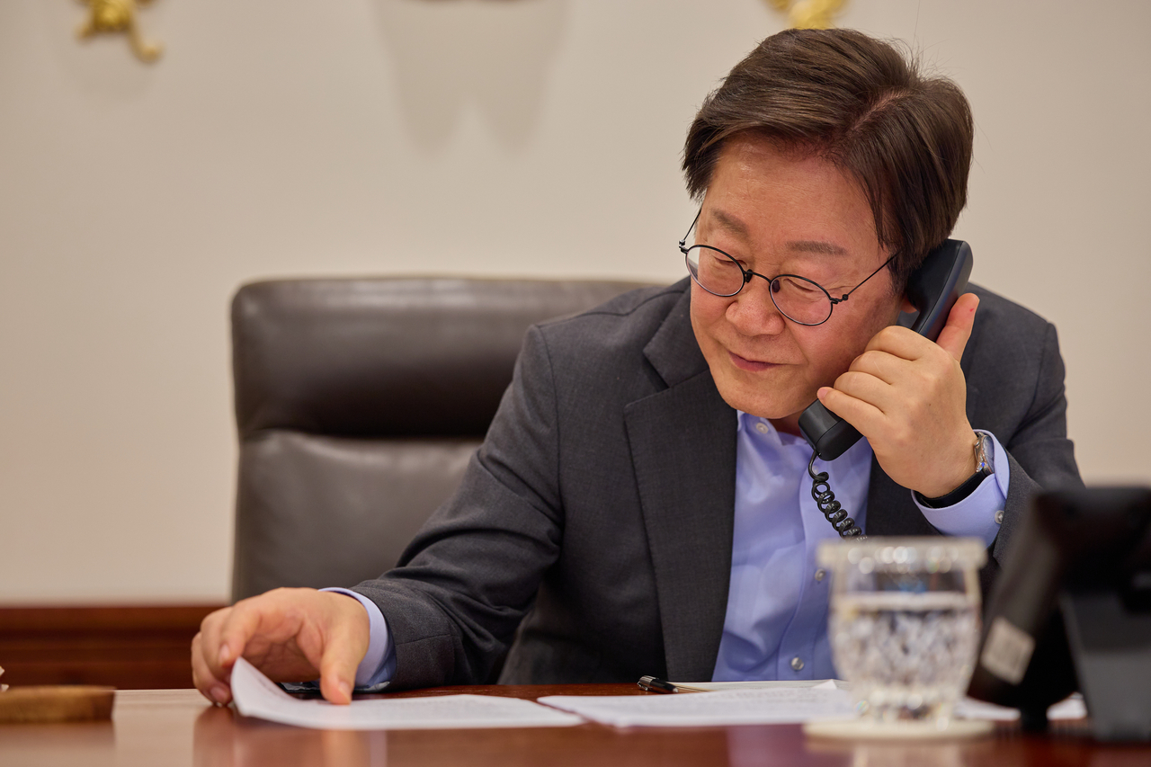 President Lee Jae Myung speaks on the phone. (Yonhap)