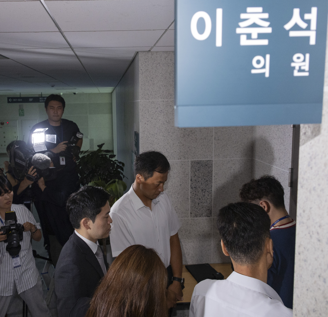 주식 차명거래 혐의를 받는 이춘석 의원의 국회 사무실에 11일 서울경찰청 금융범죄수사대 전담수사팀 관계자가 도착해 의원실 관계자와 압수수색 영장 집행을 두고 대화하고 있다. [연합]