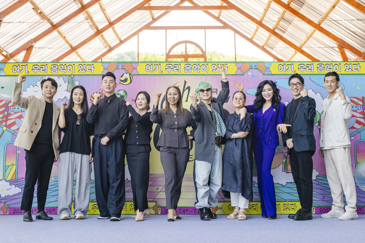 Artistic director Lee Hee-moon (fifth from right) and artists participating in the 2025 Yeowoorak Festival pose for a group photo after a press conference on June 11. (National Theater of Korea)
