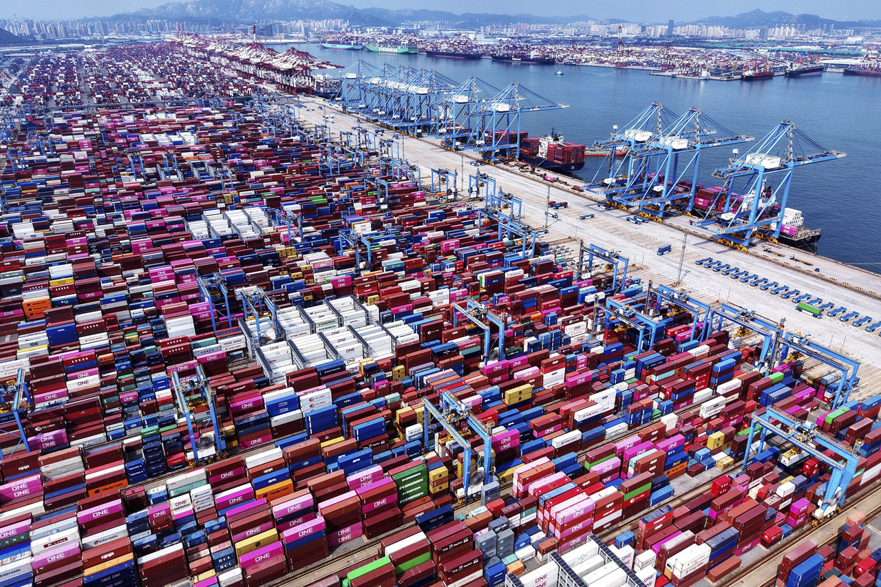 Cranes load containers and unload them from vessels at a container terminal in Qingdao in east China's Shandong province on Monday.   AP-Yonhap
