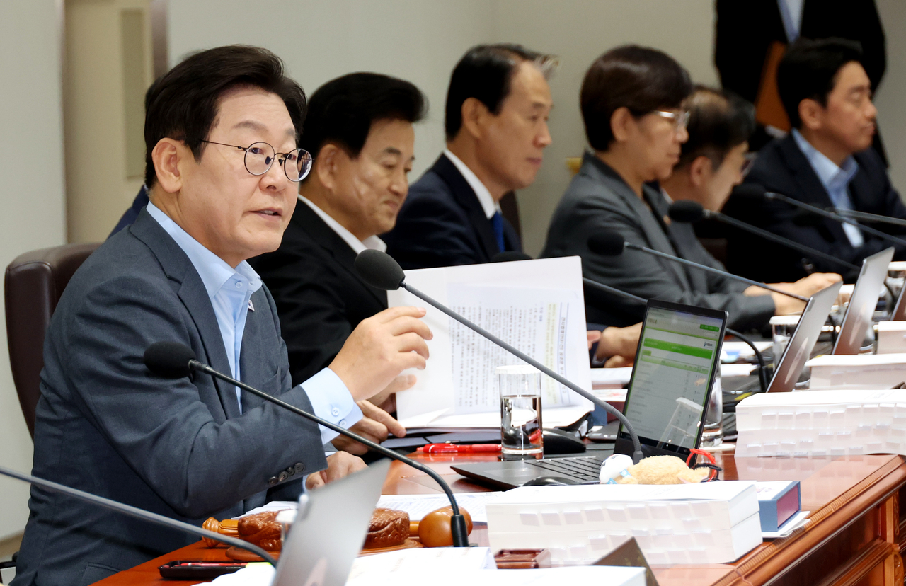 President Lee Jae Myung (left) speaks during a Cabinet meeting at the presidential office in Yongsan-gu, central Seoul, Tuesday. (Yonhap)