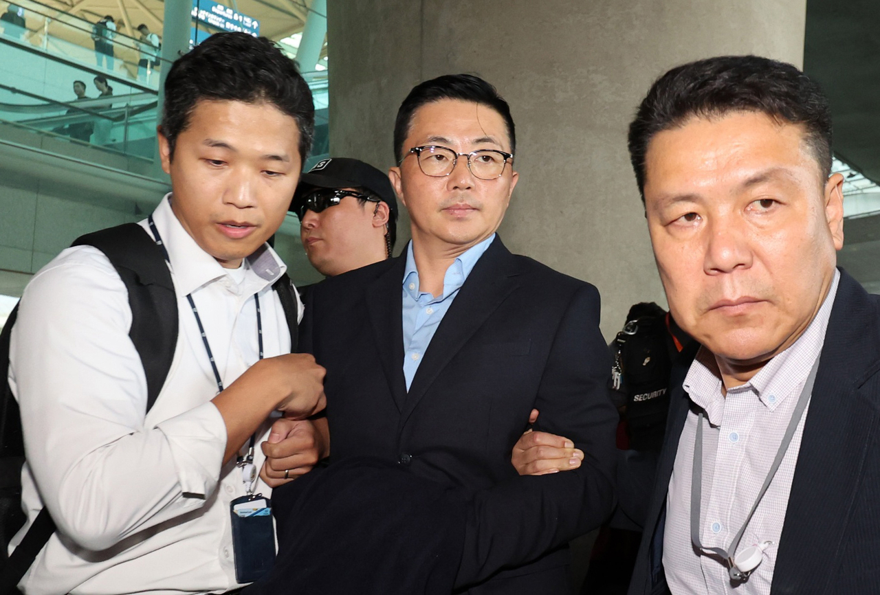 Kim Ye-seong (center), is being taken in for questioning by a special counsel upon arrival at Incheon International Airport from Vietnam on Tuesday. (Yonhap)