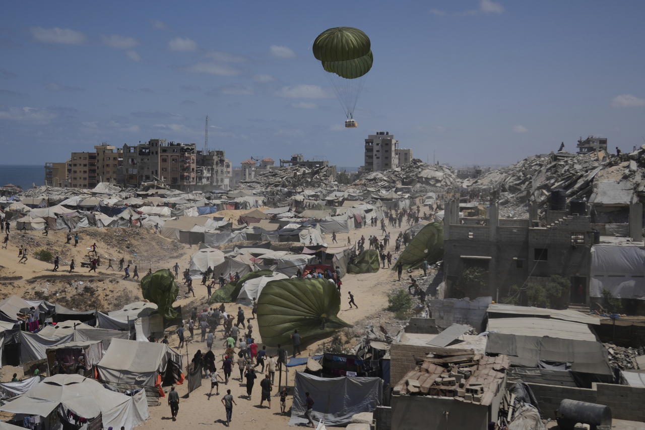 Palestinians rush to collect humanitarian aid airdropped by parachutes into Gaza City, Thursday. (AP-Yonhap)
